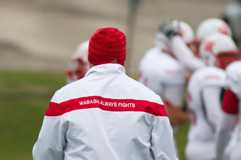 a football player in a white jacket and red hat