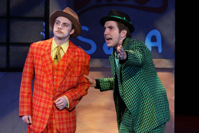 two men in suits on a stage