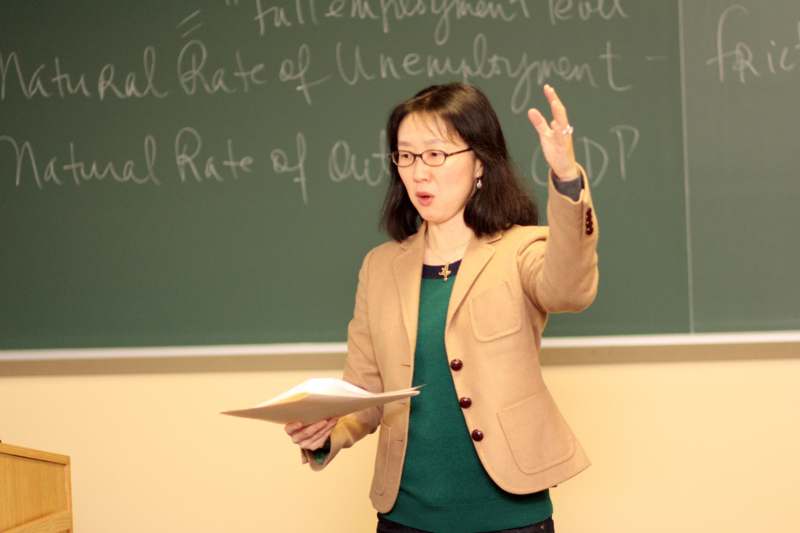 a woman standing in front of a chalkboard