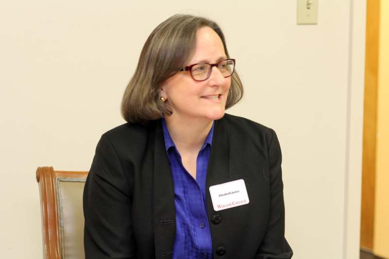 a woman wearing glasses and a name tag