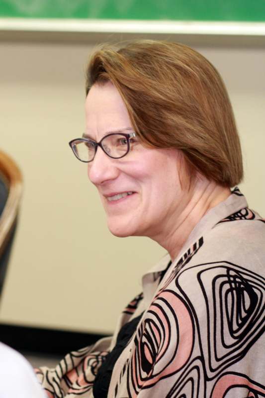 a woman with short brown hair wearing glasses