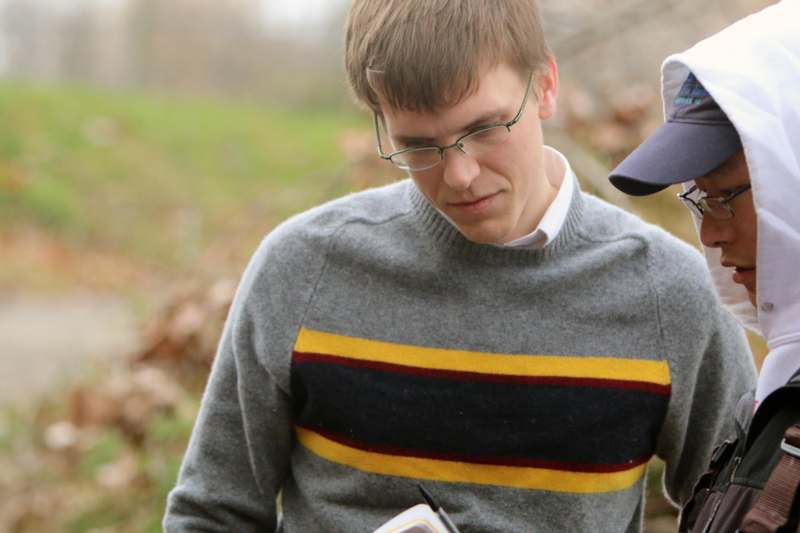 a man wearing glasses and a grey sweater