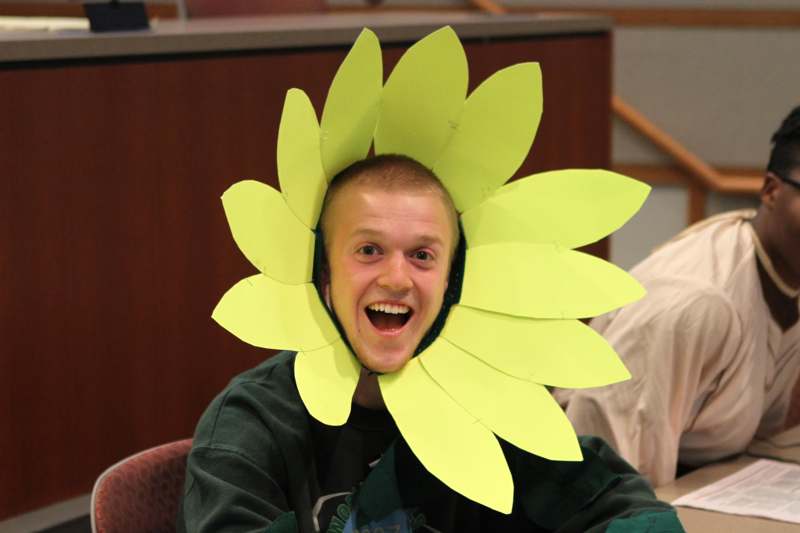 a man wearing a paper flower head piece