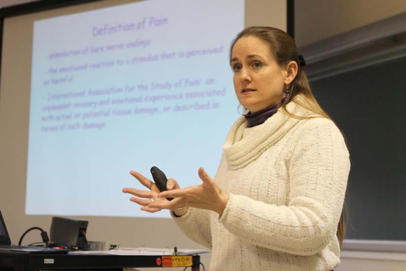 a woman in a white sweater giving a presentation