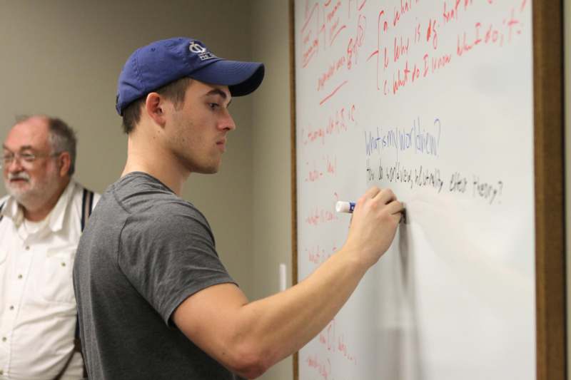 a man writing on a whiteboard