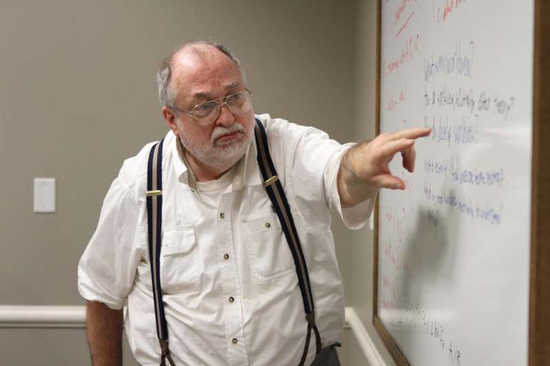 a man pointing at a whiteboard