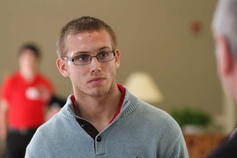 a man wearing glasses and a sweater