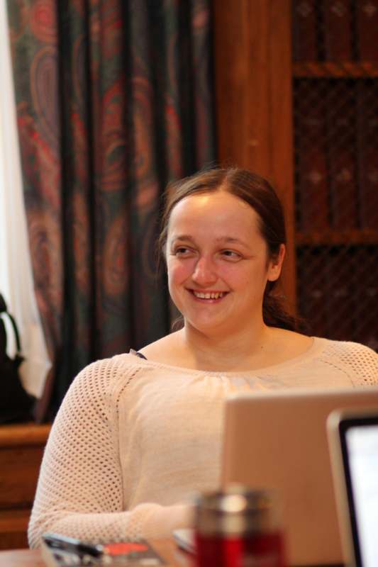 a woman smiling at a laptop