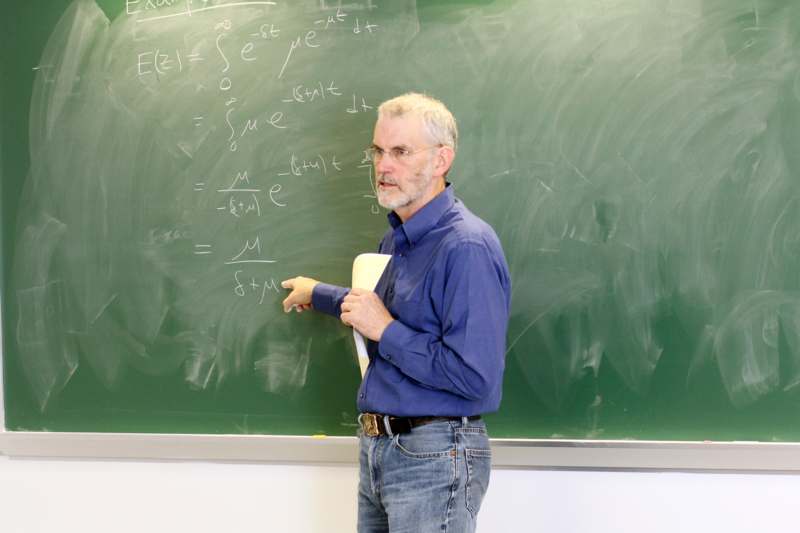 a man standing in front of a chalkboard