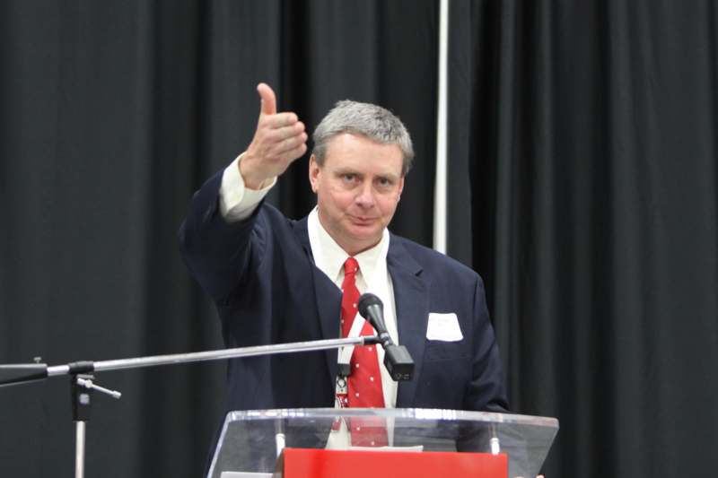 a man giving a thumbs up at a podium