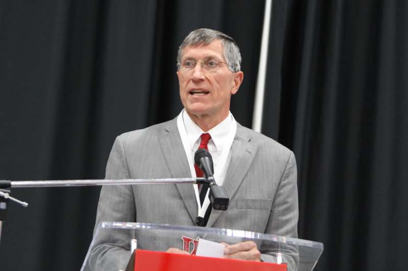 a man in a suit and tie speaking at a podium
