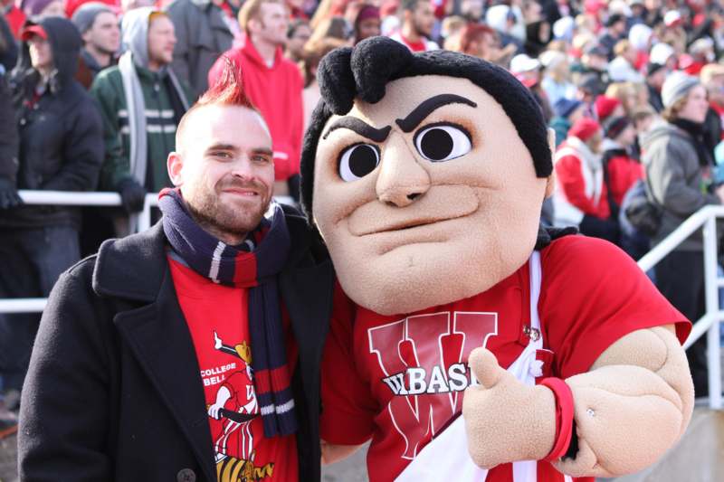 a man with a mascot posing for a picture