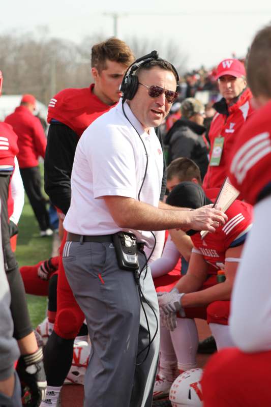 a man wearing headphones and talking to a football player