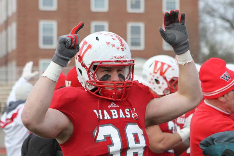 a football player in a red uniform with his hands up
