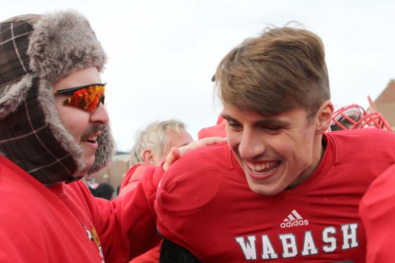 a man in red shirt with a man in a furry hat
