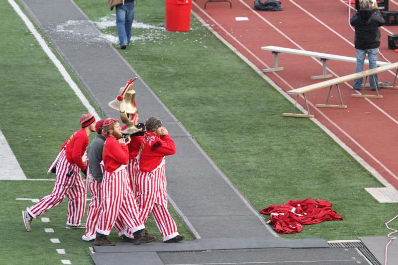 a group of people in striped pants carrying a trophy