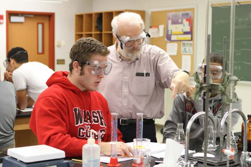 a man pointing at a man wearing goggles