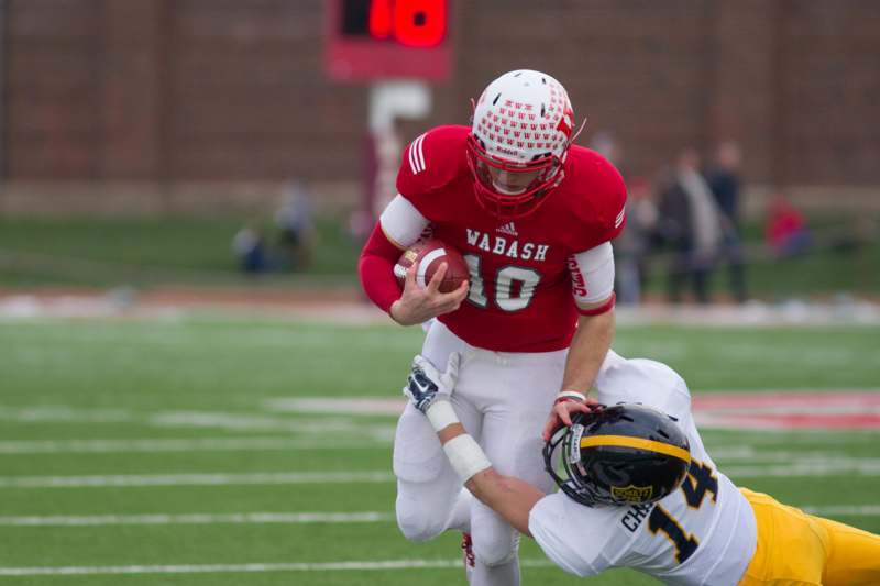 a football player in a red uniform holding the ball