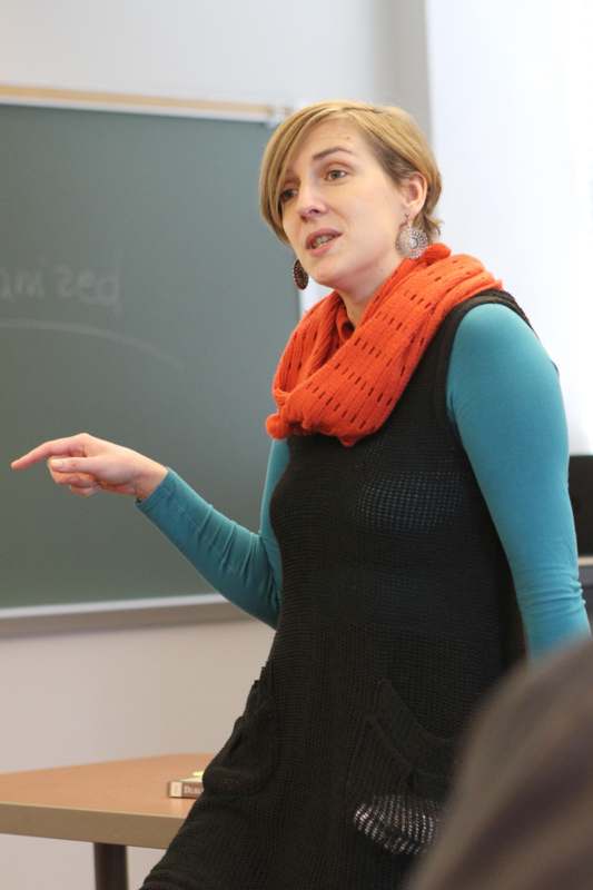a woman in a black shirt and orange scarf pointing at something