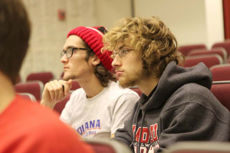 two men sitting in a lecture hall