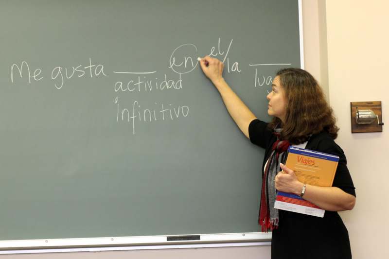 a woman writing on a chalkboard