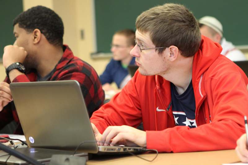 a man in a red jacket using a laptop