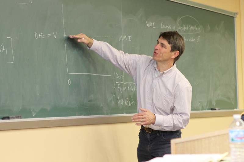 a man pointing at a blackboard