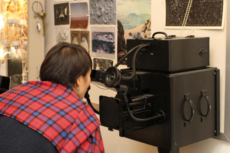 a woman looking through a large black machine