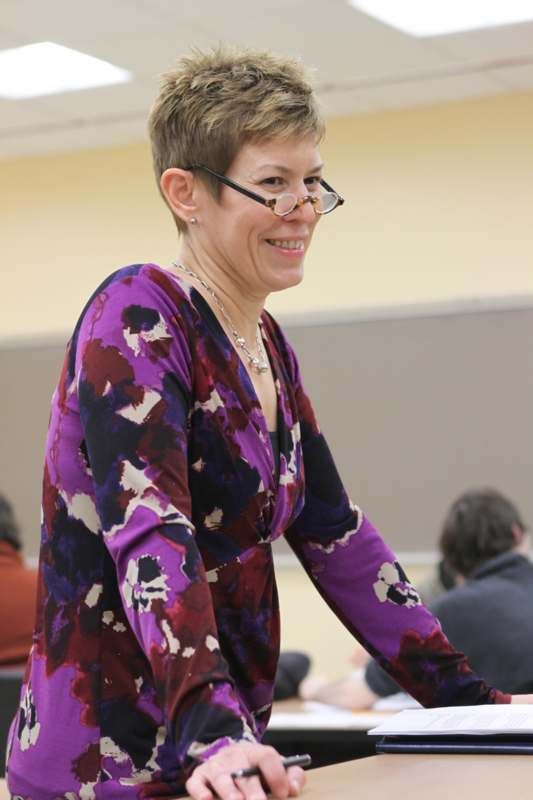 a woman wearing glasses and a purple shirt