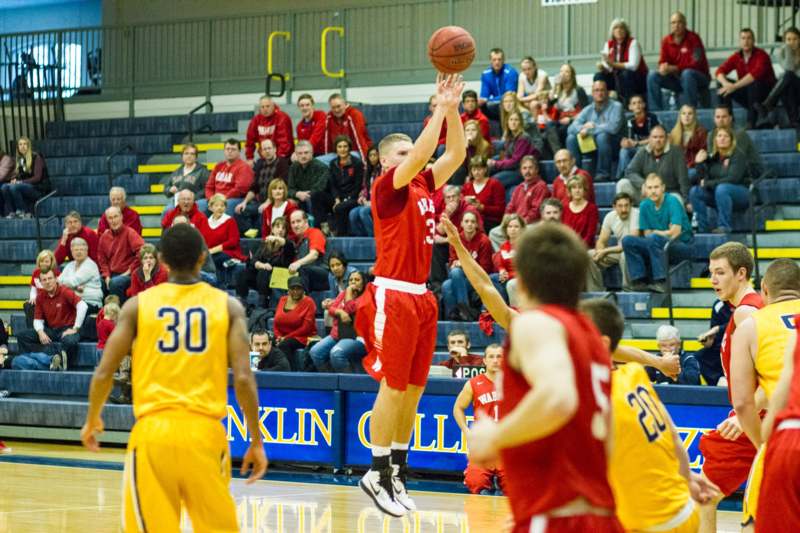 a basketball player in red and yellow uniform jumping to shoot a basketball