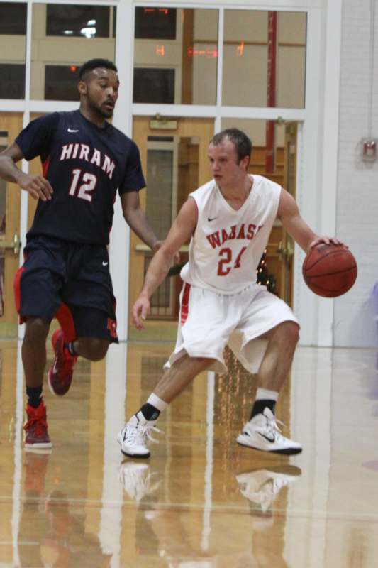 a man in a white jersey dribbling a basketball