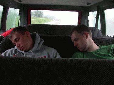 a couple of men sleeping in a car