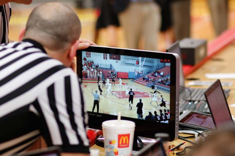 a man watching a basketball game on a computer