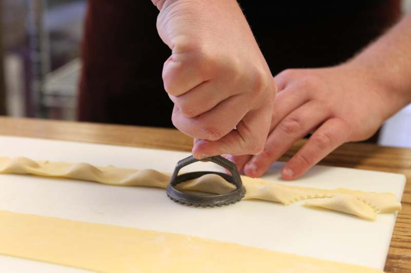 a person using a cutter to make ravioli