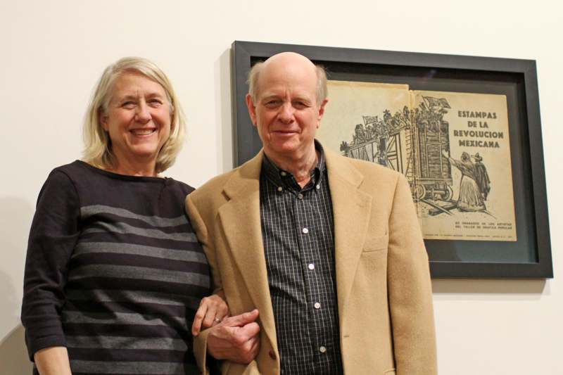 a man and woman standing in front of a picture