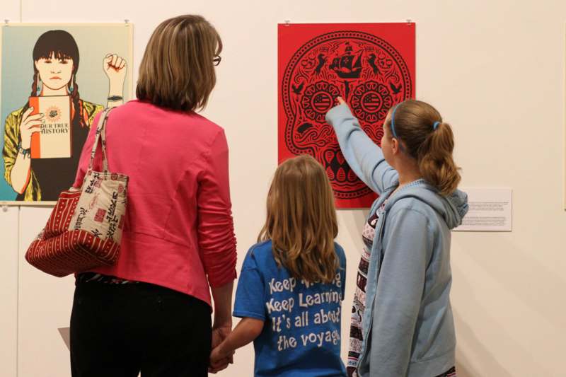 a group of people looking at a red poster