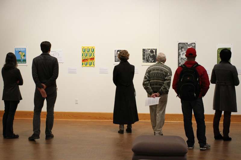 a group of people looking at art on the wall