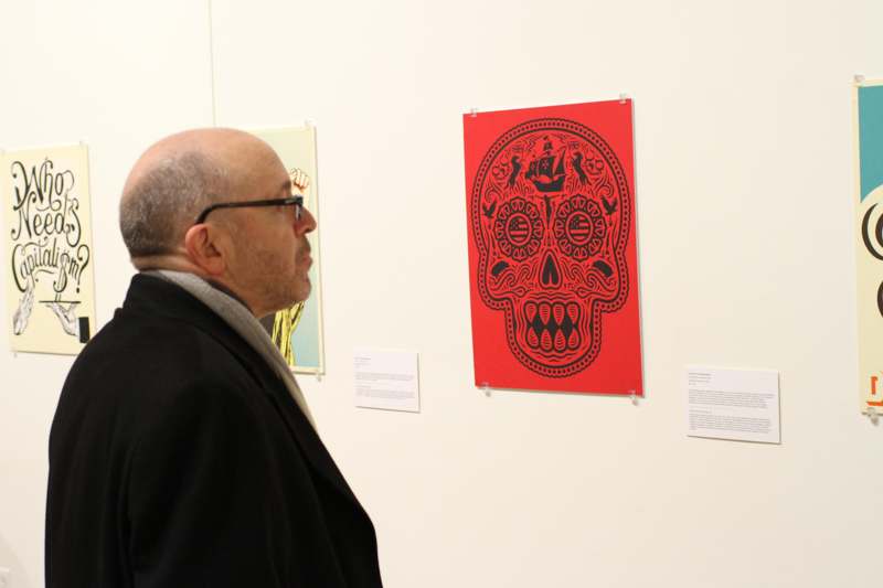 a man looking at a red skull on a wall