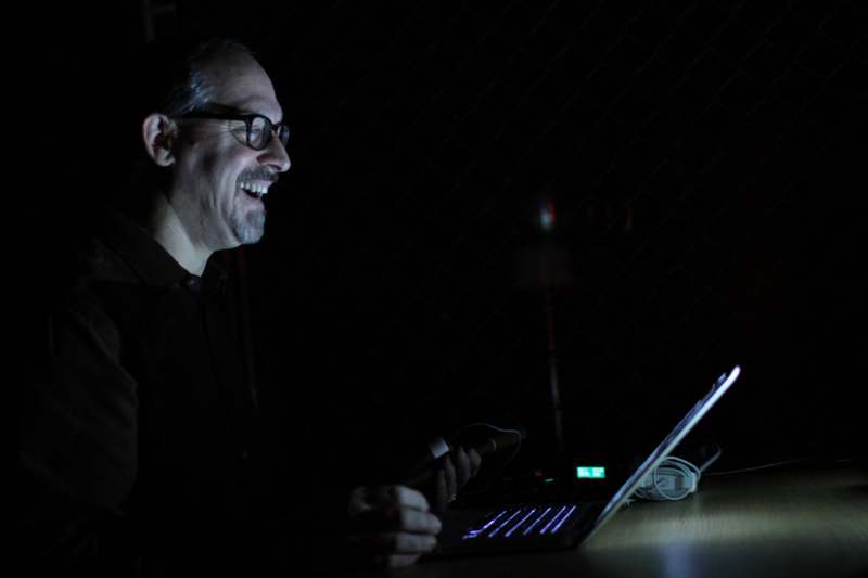 a man smiling at a laptop