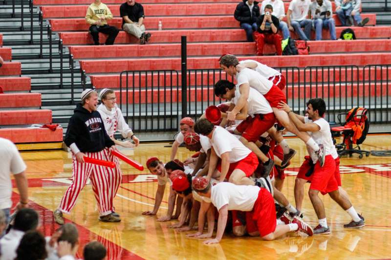 a group of people in a pile on a basketball court