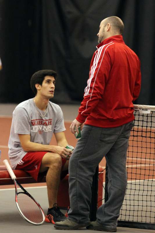 a man talking to another man on a tennis court