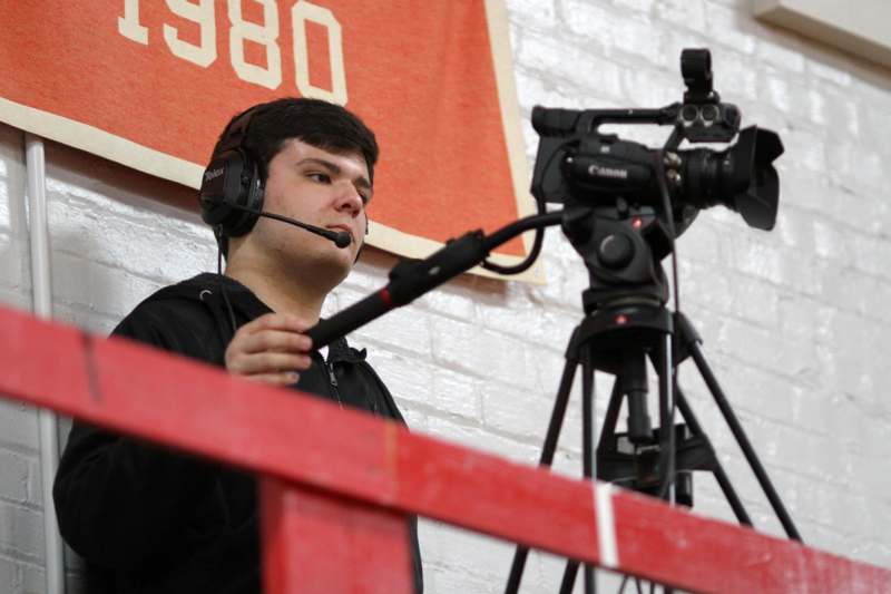 a man with headphones and microphone on a tripod