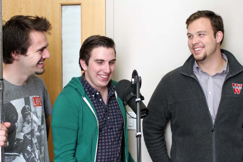a group of men standing next to a microphone