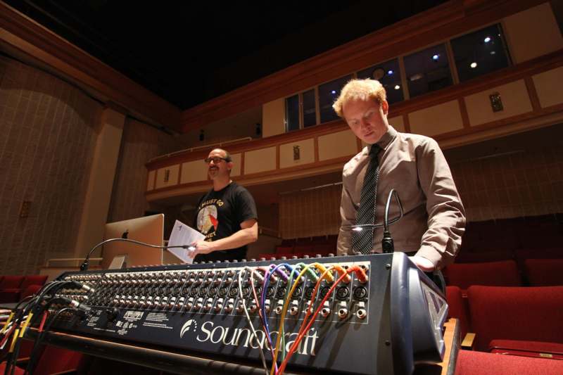 a man standing behind a sound mixer