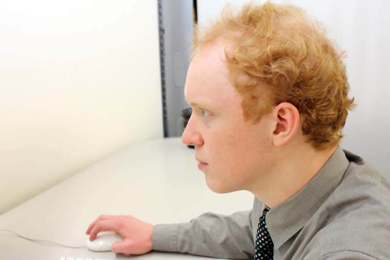 a man sitting at a desk using a computer