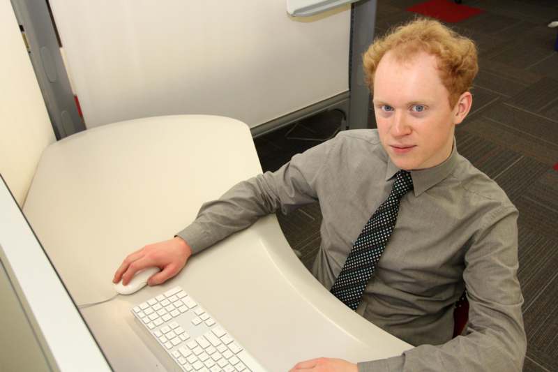 a man sitting at a desk with a computer mouse