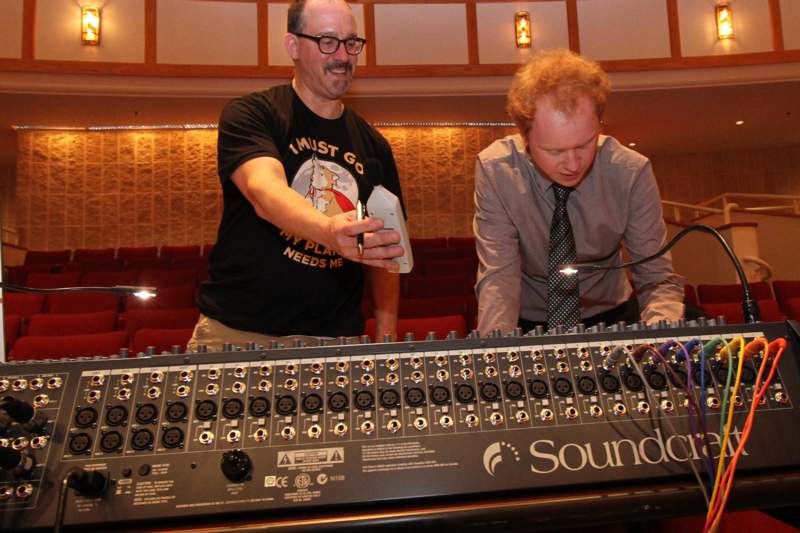a man standing next to a large sound mixer