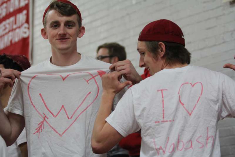 a man holding a shirt with writing on it