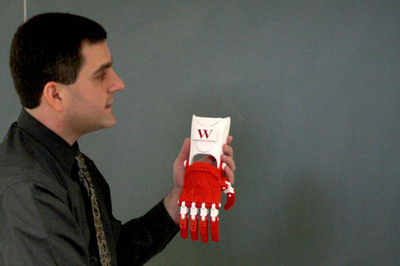 a man holding a red and white robot glove