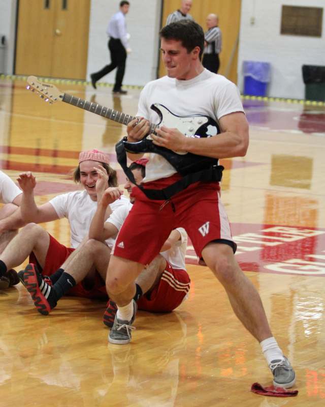 a man playing a guitar on a basketball court